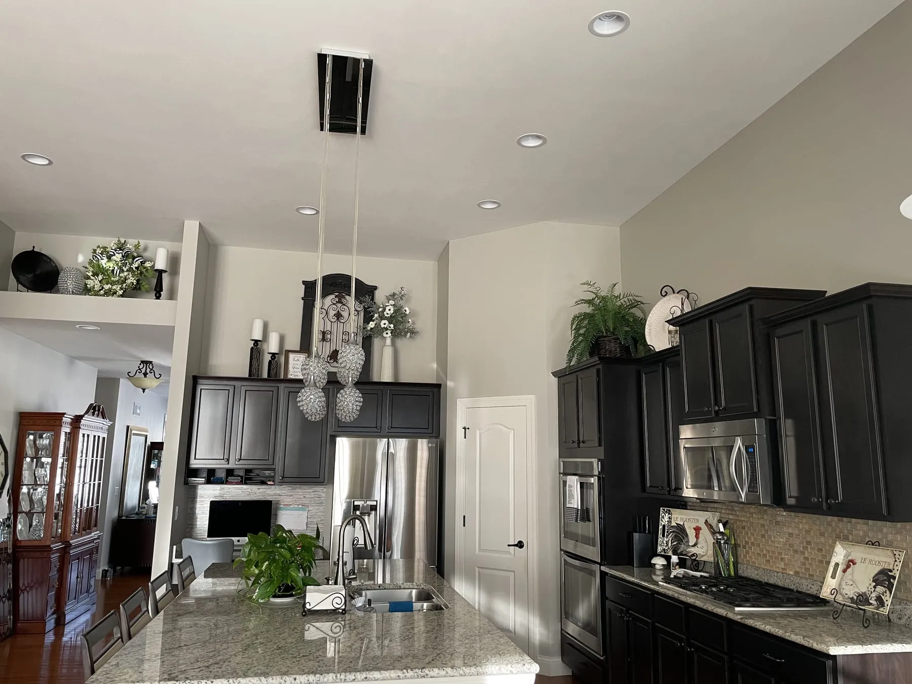 Open kitchen with dark-painted cabinets and a vaulted ceiling