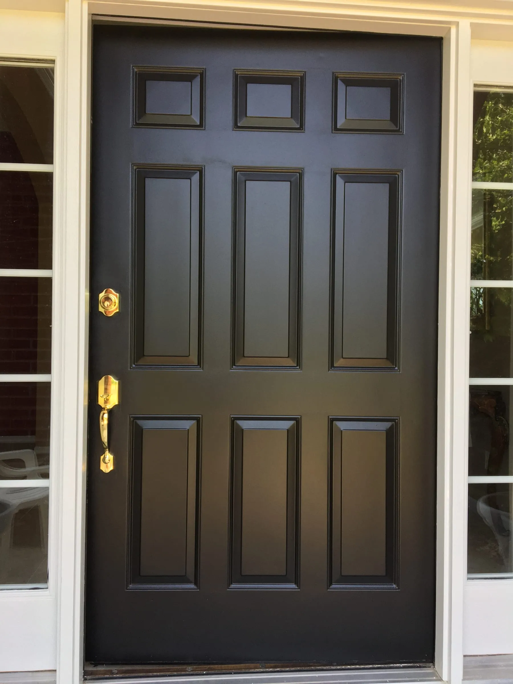 Front door refinished in a smooth, rich black